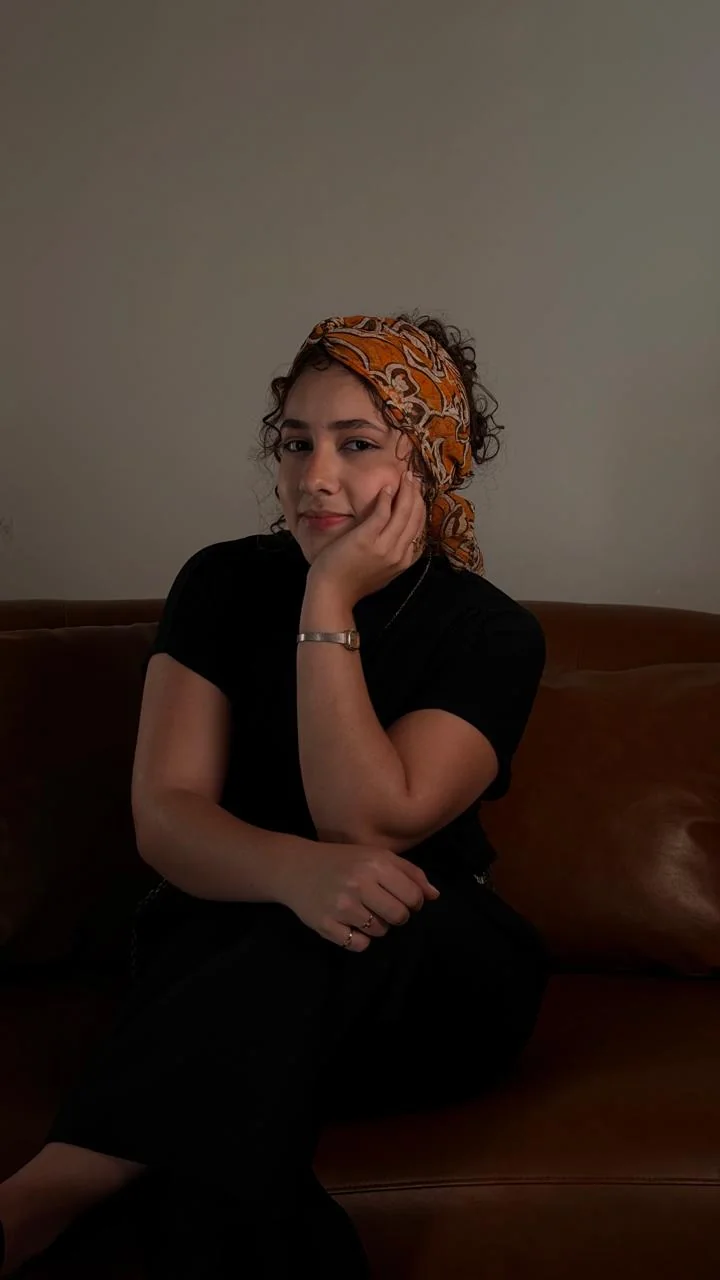 Retrato de Maria Fernanda sentada, com lenço estampado no cabelo.